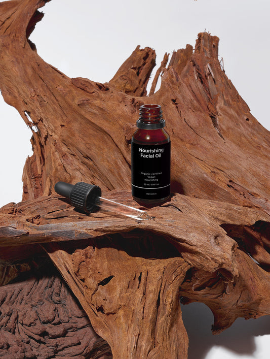 Nourishing facial oil bottle with dropper on a wooden surface