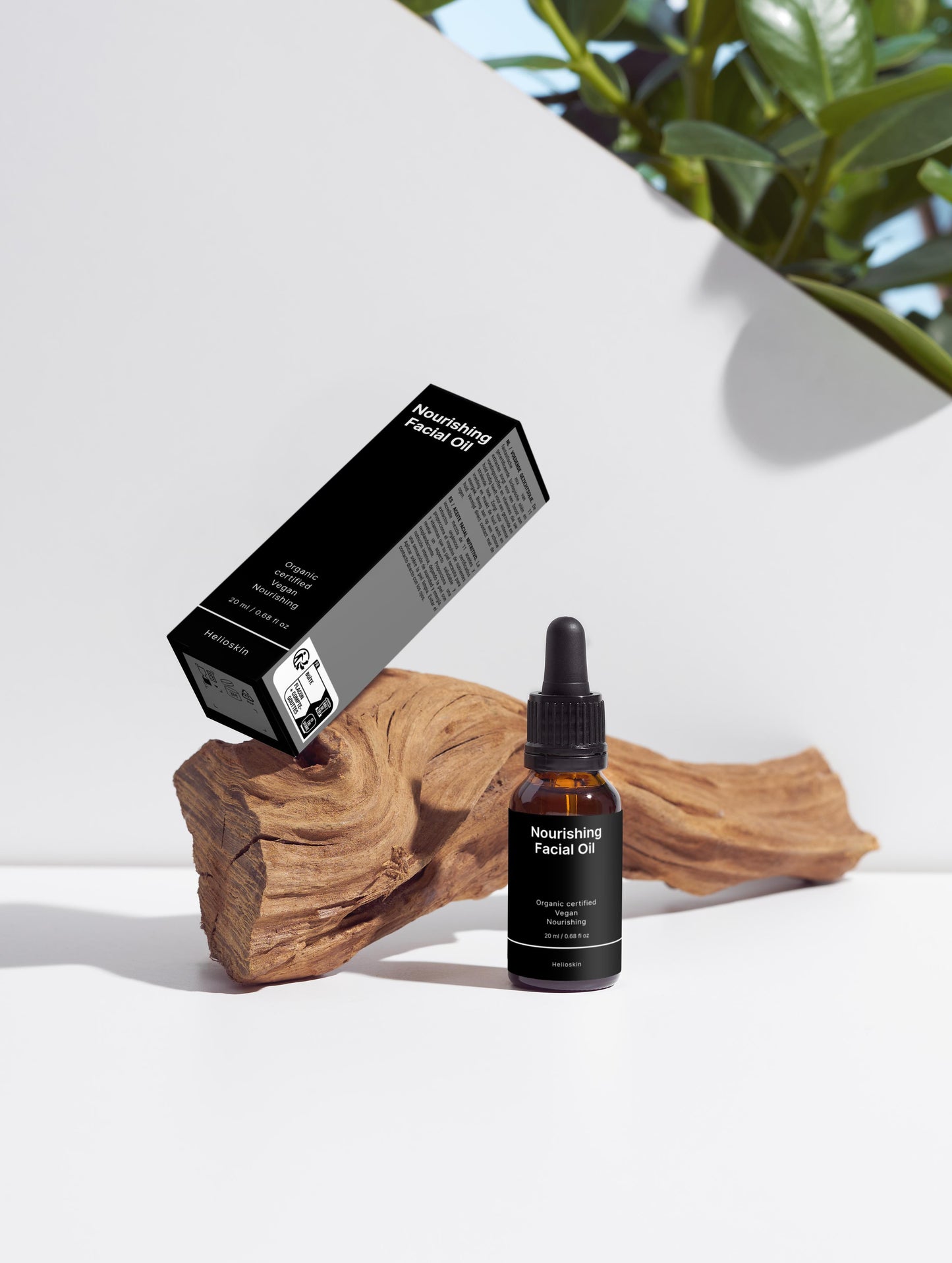 Facial oil bottle and packaging on a wooden block with a white background