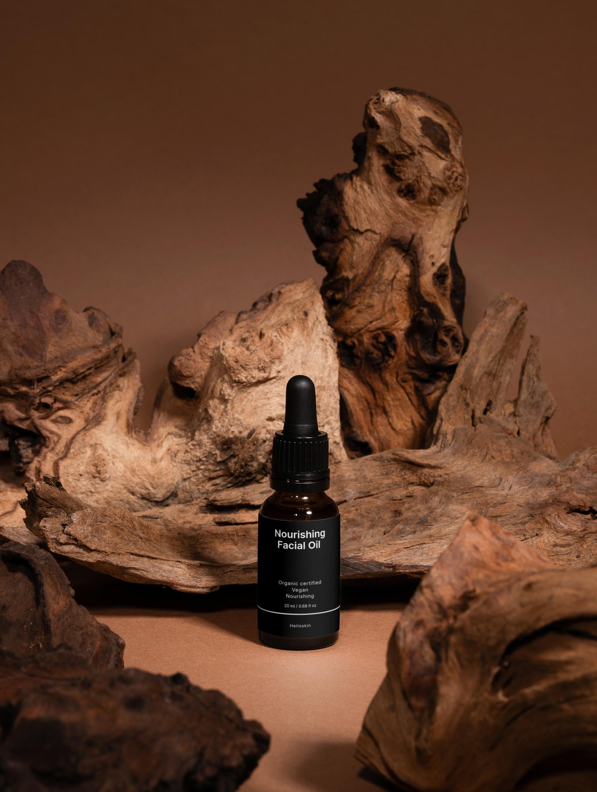 Bottle of Nourishing Facial Oil with dropper on a wooden surface