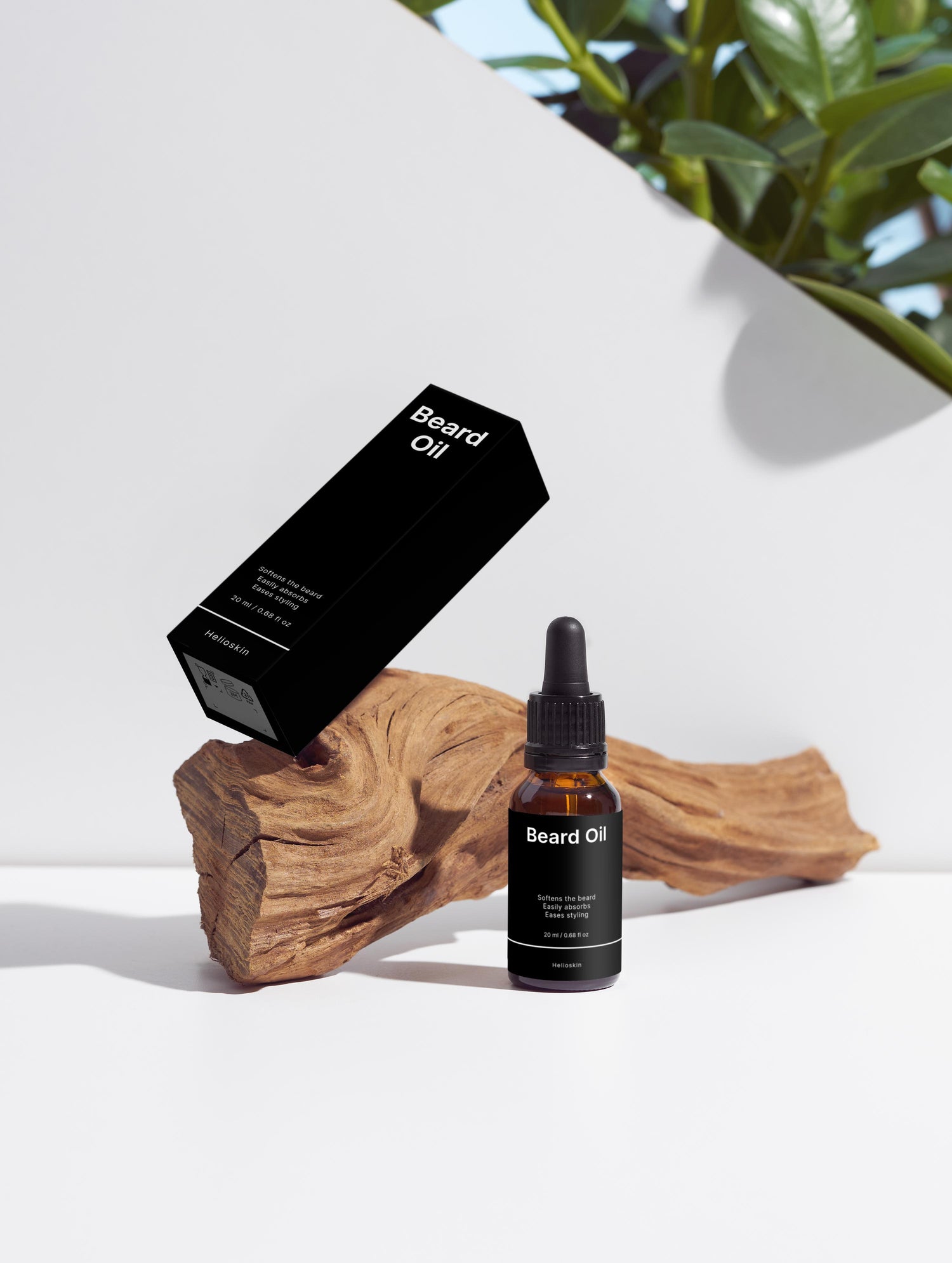 Beard oil bottle and packaging on a white surface with a wooden block and plant in the background