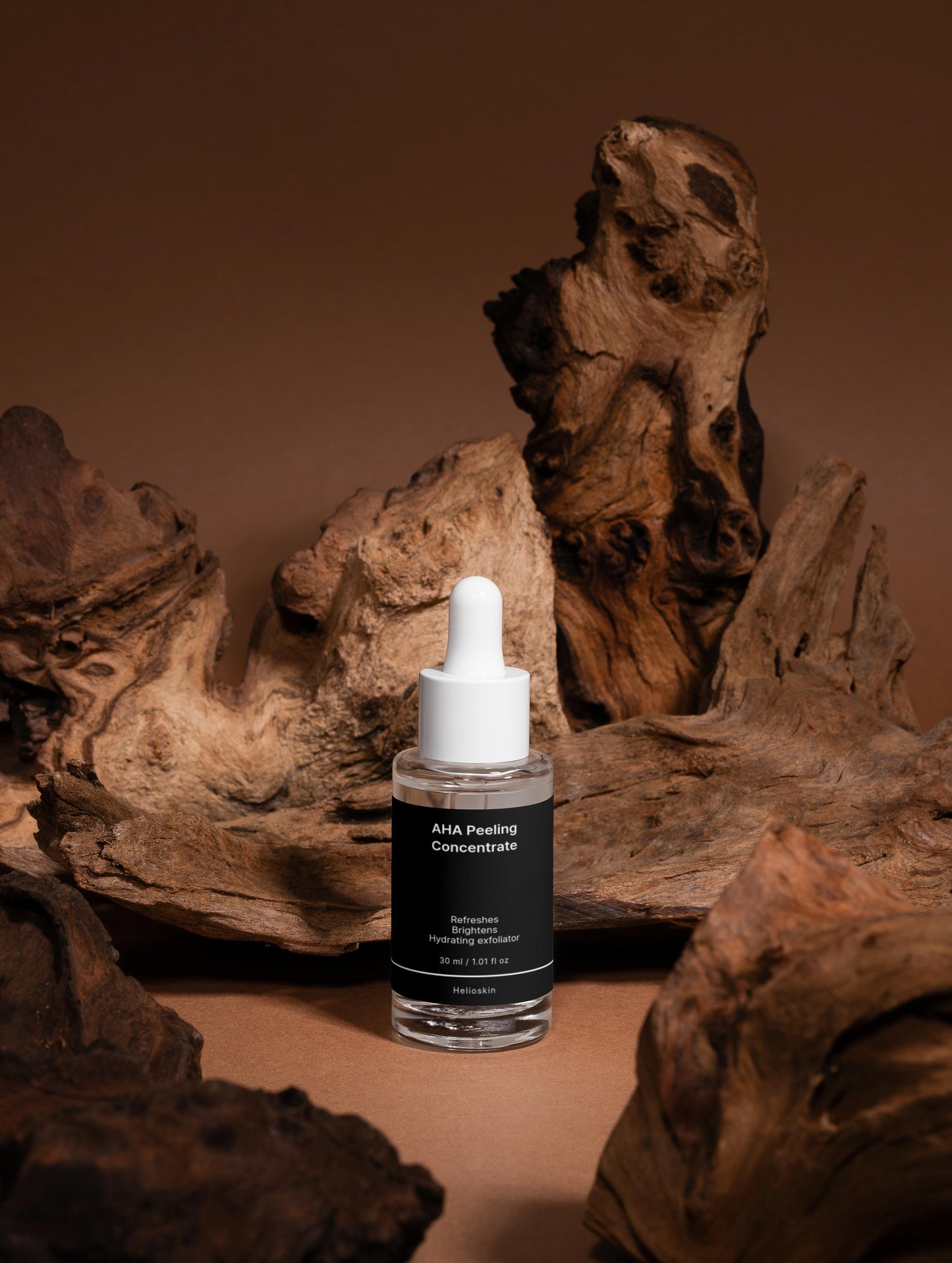 Skincare serum bottle with dropper on a brown background