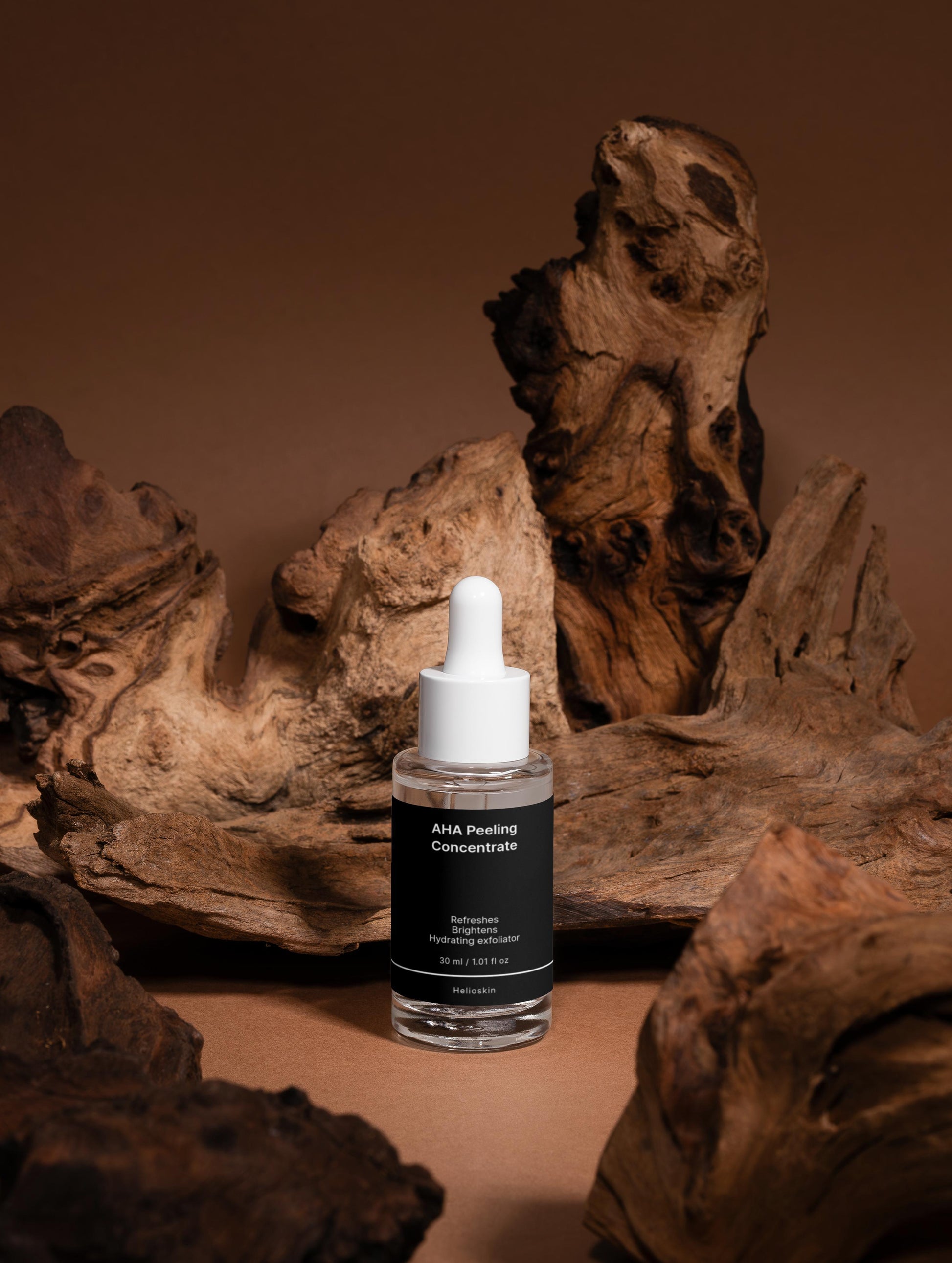 Skincare serum bottle with dropper on a brown background