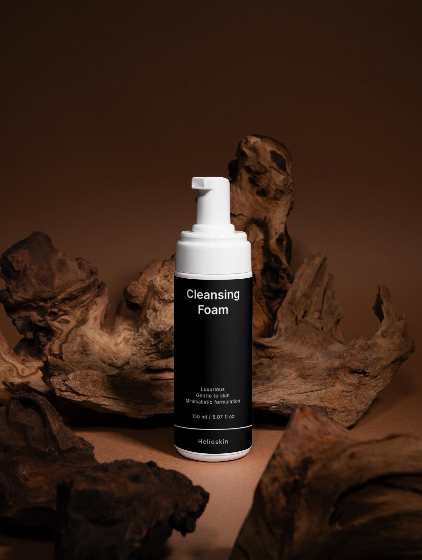 Cleansing foam bottle with pump dispenser on a brown background