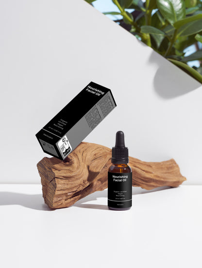 Facial oil bottle and packaging on a wooden block with a white background