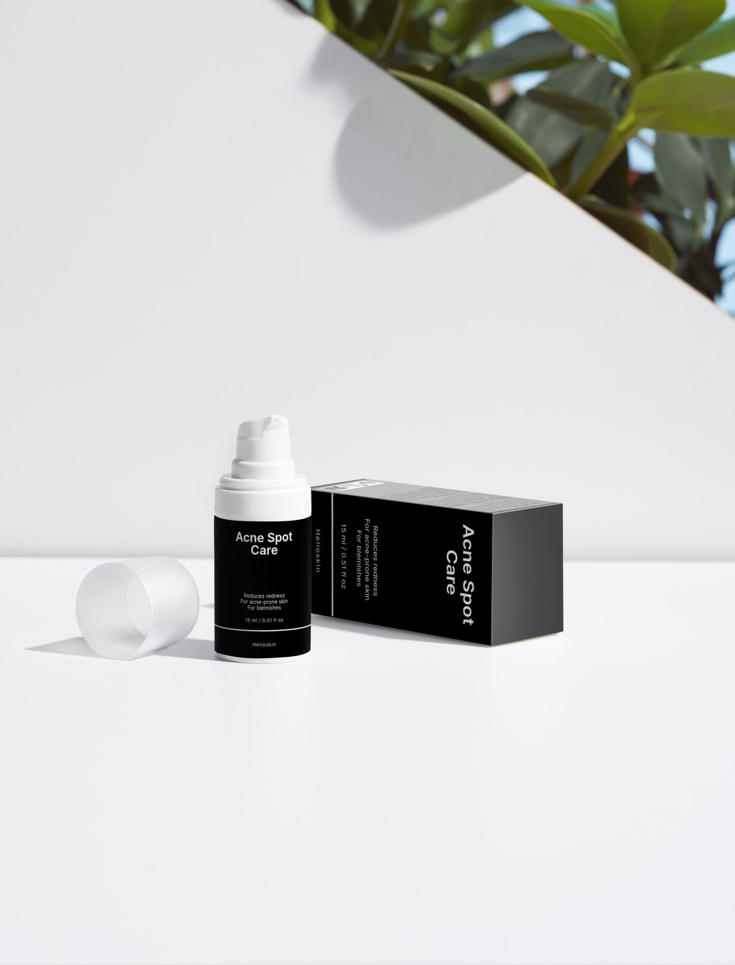 Skincare bottle and packaging on a white background with greenery in the corner