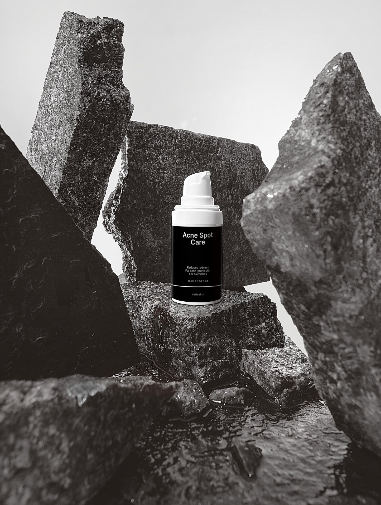 Skincare product labeled 'Acne Spot Care' on a rocky surface